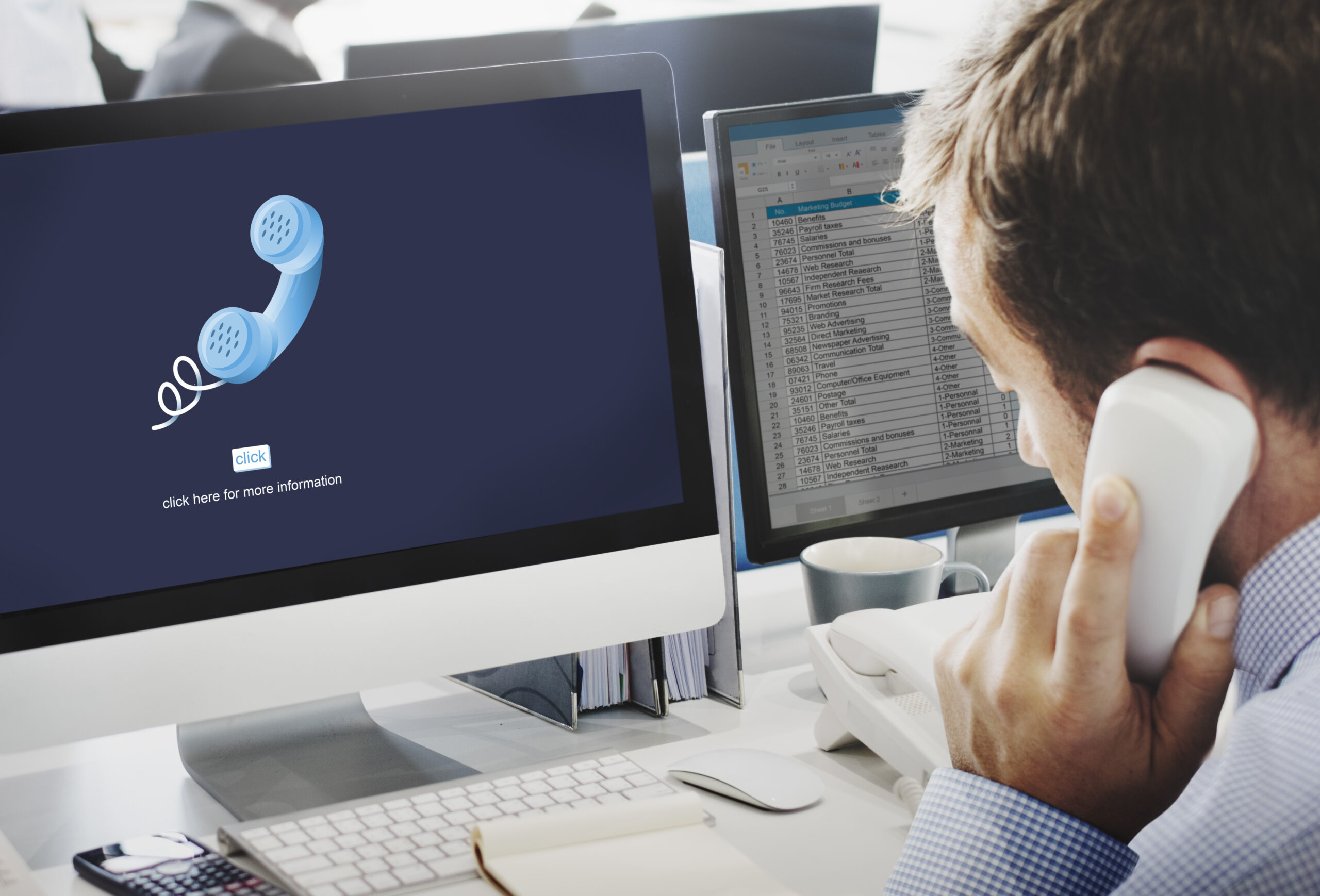Salarié au téléphone devant son poste informatique