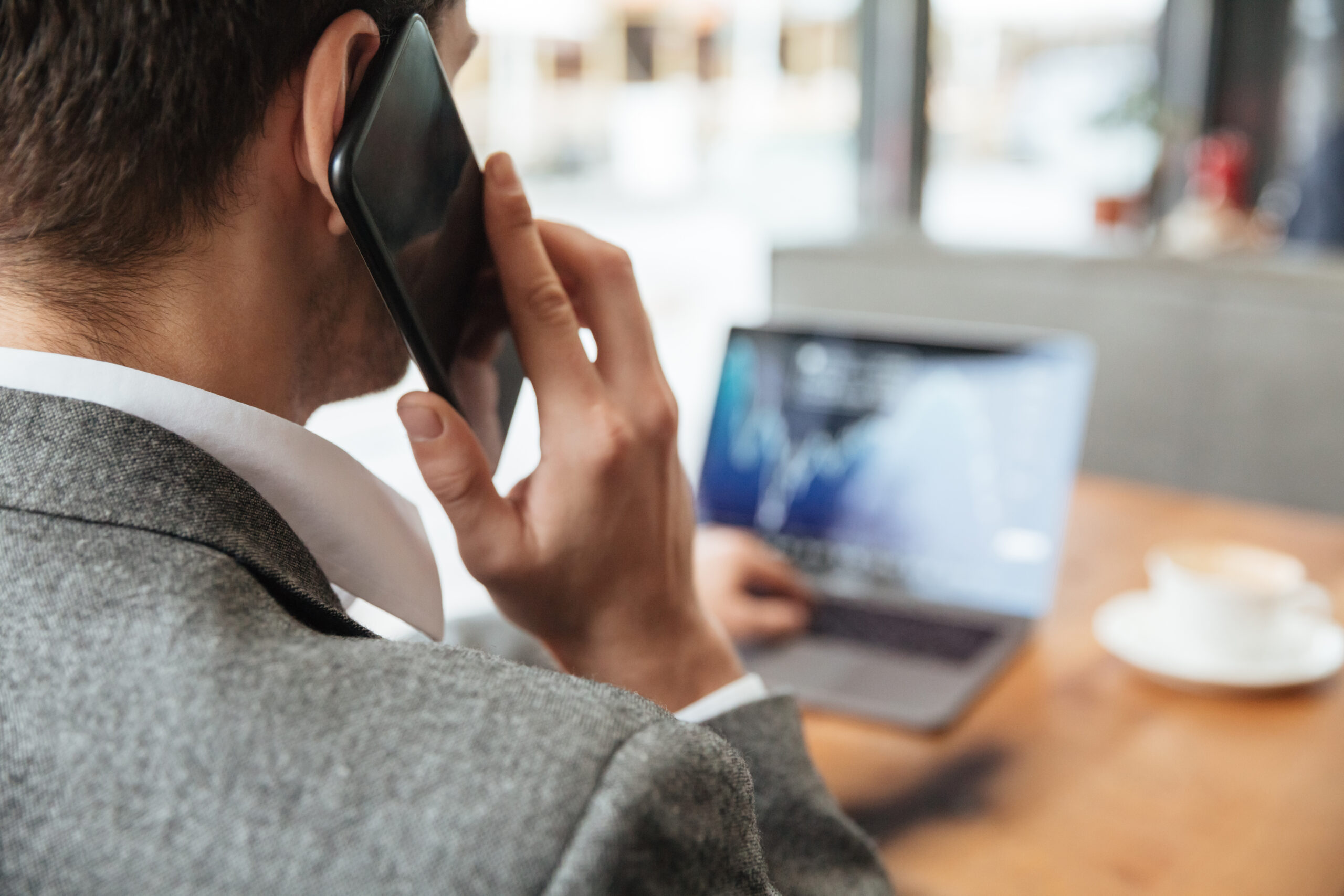 Commercial en déplacement au téléphone avec son smartphone professionnel
